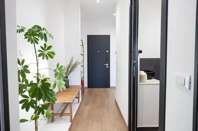 a hallway with a blue door and plants at Taléa - Design Apartment a Palermo in Palermo