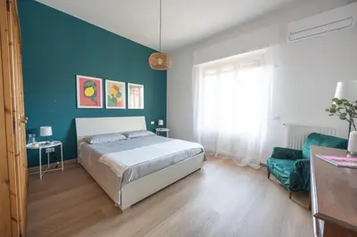a bedroom with a bed and a blue wall at Taléa - Design Apartment a Palermo in Palermo