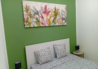 a bedroom with a bed and a painting on the wall at Sicilia Bedda Casa Vacanze in Lascari