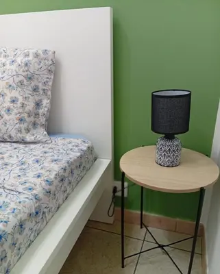 a lamp sitting on a table next to a bed at Sicilia Bedda Casa Vacanze in Lascari