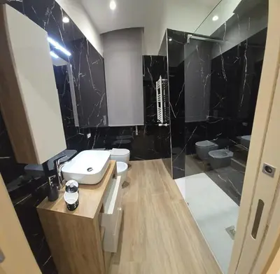 a black and white bathroom with a sink and a toilet at La Casa di MaMA in Palermo