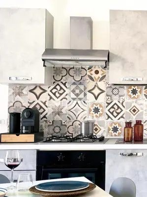 a kitchen with a stove and a tile wall at La Majolica Appartamento di design con terrazzino privato in centro in Palermo