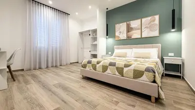 a bedroom with a bed and a green wall at Street316 in Cinisi