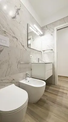 a white bathroom with a toilet and a sink at Street316 in Cinisi