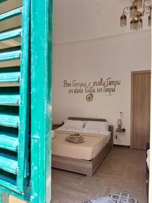 a bedroom with a bed with a sign on the wall at Camera Verga in Palermo