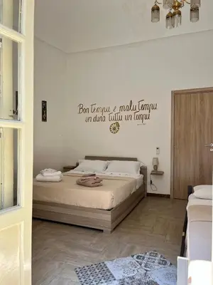 a bedroom with two beds and words on the wall at Camera Verga in Palermo