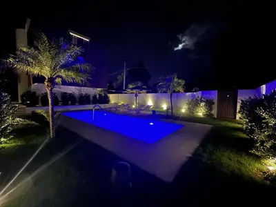 a backyard with a swimming pool at night at Design Villa with private pool in Carini