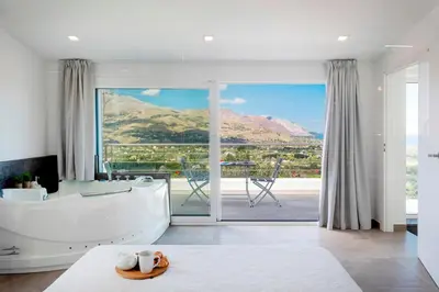 a large bathroom with a tub and a large window at VILLA DEI SOSPIRI 4, Emma Villas in Castellammare del Golfo