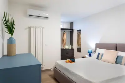 a small bedroom with a bed and a blue cabinet at VILLA DEI SOSPIRI 4, Emma Villas in Castellammare del Golfo