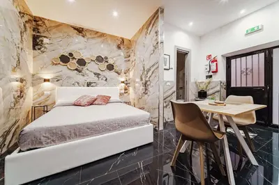 a bedroom with a bed and a table and a desk at Kamel home in Palermo