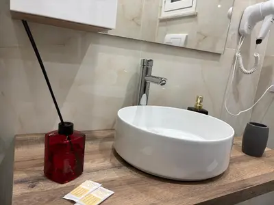 a bathroom with a white sink on a counter at Kamel home in Palermo