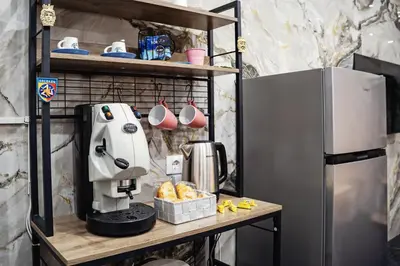 a coffee maker on a table next to a refrigerator at Kamel home in Palermo