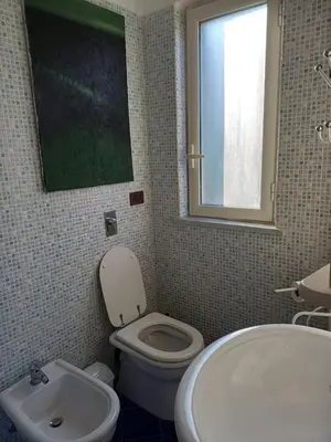 a bathroom with a white toilet and a sink at Villa sul mare in Isola delle Femmine