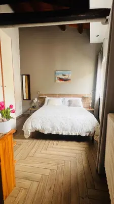 a bedroom with a large bed and a wooden floor at Kasa Kaletta Rooms in Palermo