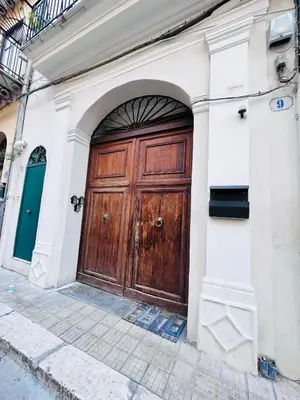 a large wooden door on the side of a building at Kasa Kaletta Rooms in Palermo