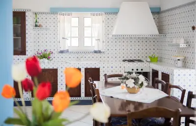 a kitchen with a table with flowers on it at Villa Cielo d'Alcamo Marina in Alcamo