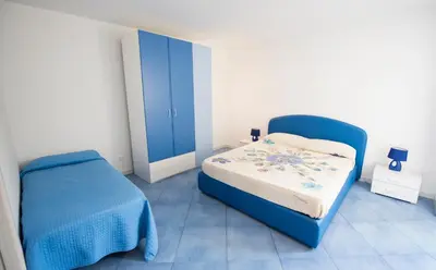 a bedroom with a blue bed and a blue chair at Villa Cielo d'Alcamo Marina in Alcamo