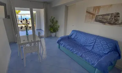 a living room with a blue couch and a table at Villa Cielo d'Alcamo Marina in Alcamo