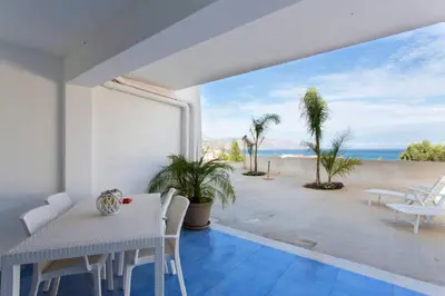 a white dining room with a view of the ocean at Villa Cielo d'Alcamo Marina in Alcamo