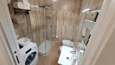 a bathroom with a shower and a washing machine at Siciliano Palace - Deluxe Apartments & Spa in Bagheria
