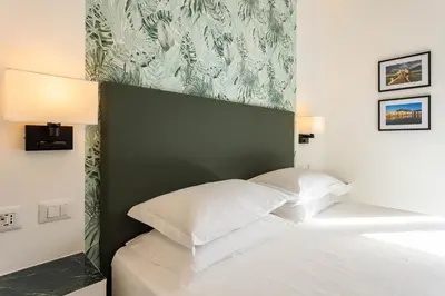 a bedroom with a white bed with a green headboard at URBAN Palermo DOWNTOWN in Palermo