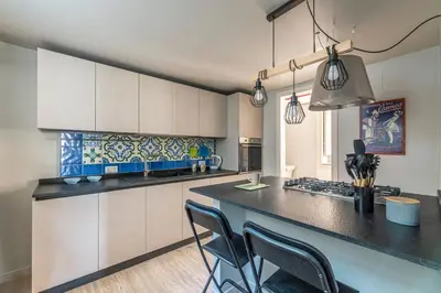 a kitchen with white cabinets and a black counter top at Central City Apartment by Wonderful Italy in Palermo