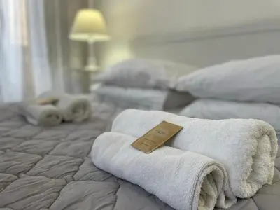 a pile of towels on a bed in a room at BB Essenze Club in Palermo