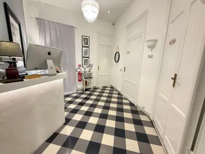 a hallway with a checkered floor and a computer on a counter at BB Essenze Club in Palermo