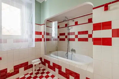 a bathroom with a tub and red and white tiles at Un Giardino Segreto a Palermo by Wonderful Italy in Palermo