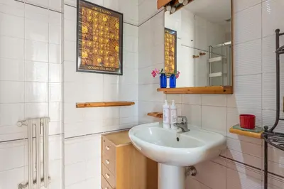 a white bathroom with a sink and a mirror at Un Giardino Segreto a Palermo by Wonderful Italy in Palermo