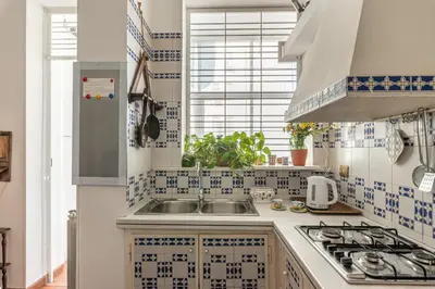 a kitchen with blue and white tiles on the wall at Un Giardino Segreto a Palermo by Wonderful Italy in Palermo