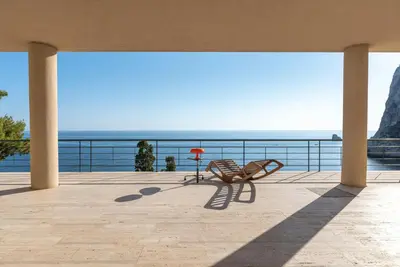 a bench sitting on a porch overlooking the ocean at Modernist Villa With Private Sea Access in Bagheria