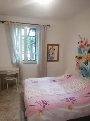 a bedroom with a pink bed with a window at Casa Siciliana Altarbiah in Trabia