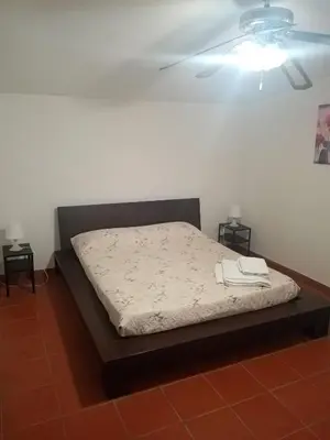 a bed in a room with two night stands at Casa Siciliana Altarbiah in Trabia