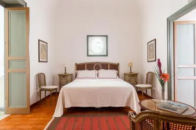 a bedroom with a bed and two chairs and a table at Baglio del Grillo in Grisi