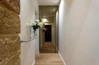 a hallway with white walls and a hallway with flowers on a wall at Isidoro Luxury Suites in Palermo