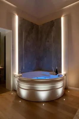 a bath tub in a room with a stone wall at Isidoro Luxury Suites in Palermo