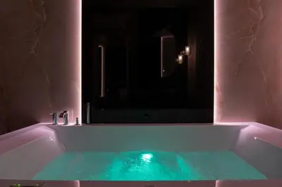 a bathroom with a tub with green water in it at Isidoro Luxury Suites in Palermo