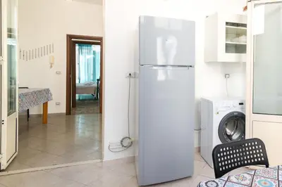 a white refrigerator in a kitchen with a washing machine at GuestHouse - 21 Steps to Everywhere in Palermo in Palermo