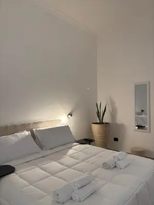 a bedroom with a large white bed with towels on it at qanatapartment in Palermo