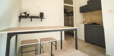 a kitchen with a counter and stools in a room at qanatapartment in Palermo