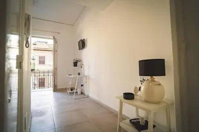 a room with a table with a lamp on it at qanatapartment in Palermo