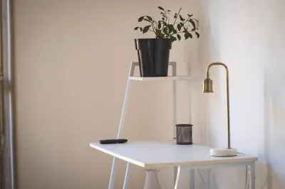 a white table with a plant on top of it at qanatapartment in Palermo