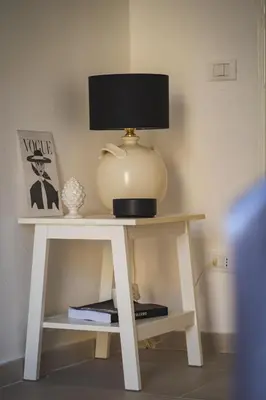 a white table with a lamp on top of it at qanatapartment in Palermo