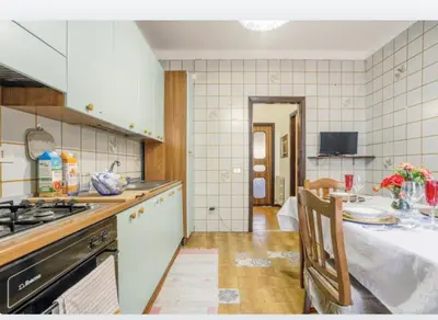 a kitchen with a stove and a table in it at incantevole casa vacanze myu in Cinisi