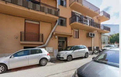 two cars parked in front of a building at incantevole casa vacanze myu in Cinisi