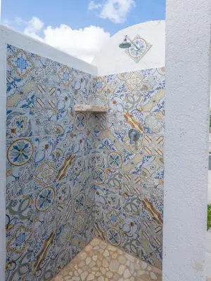 a bathroom with a wall covered in mosaics at Villa Aura Scopello in Castellammare del Golfo