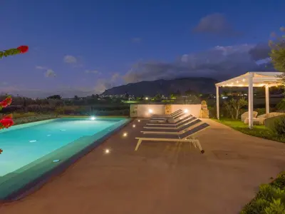 a swimming pool with lounge chairs and a gazebo at Villa Aura Scopello in Castellammare del Golfo