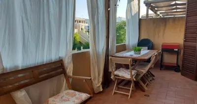 a balcony with a table and chairs and a window at Casa Alhena in San Vito lo Capo
