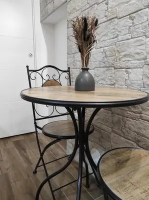 a wooden table with two chairs and a vase on it at SottoCapo House in Palermo